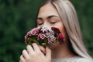 femme sent des fleurs cueillies