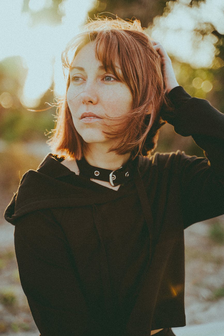 redhead woman in black clothes posing outdoors