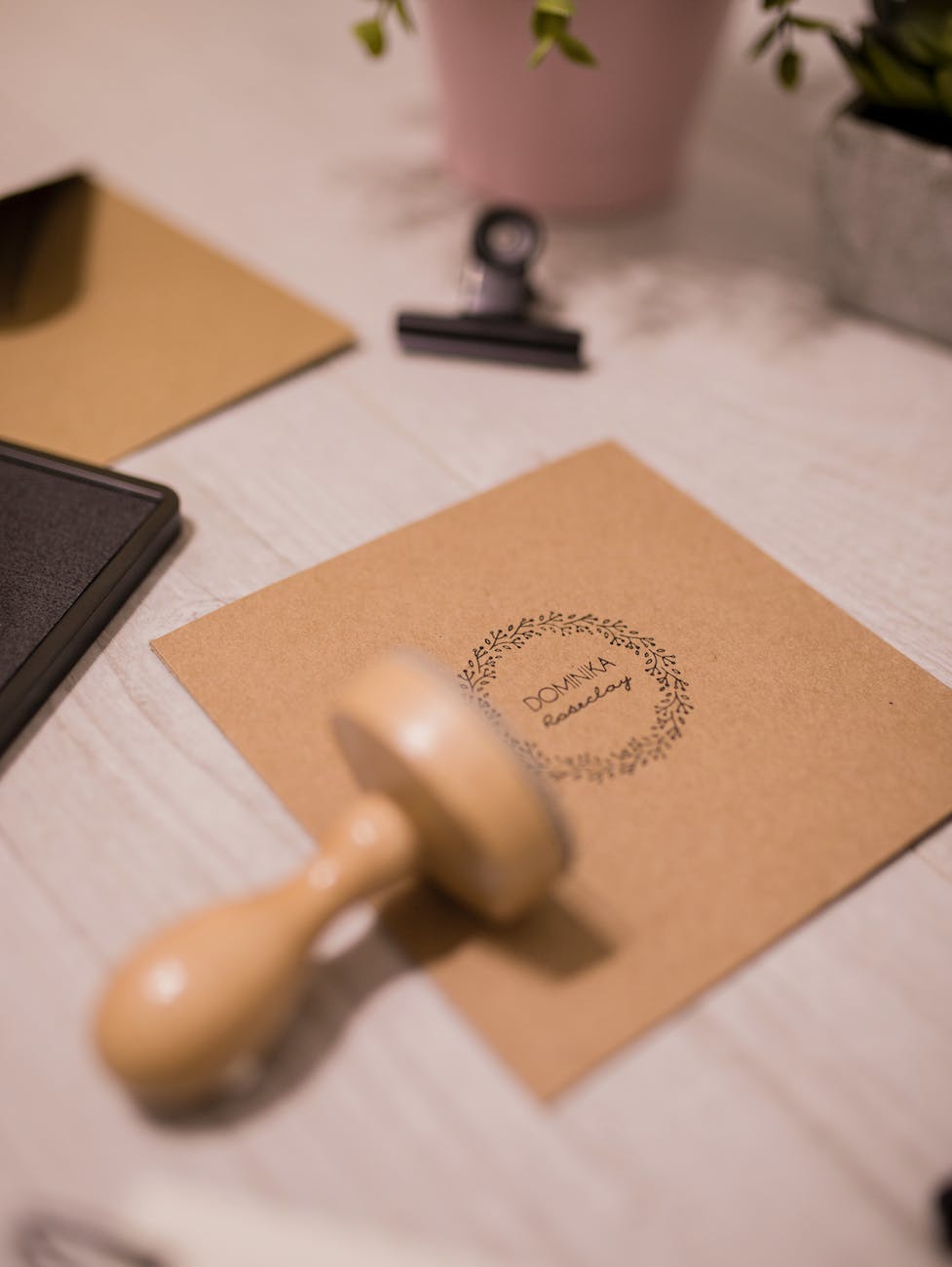 wooden stamp and invitation card on white table