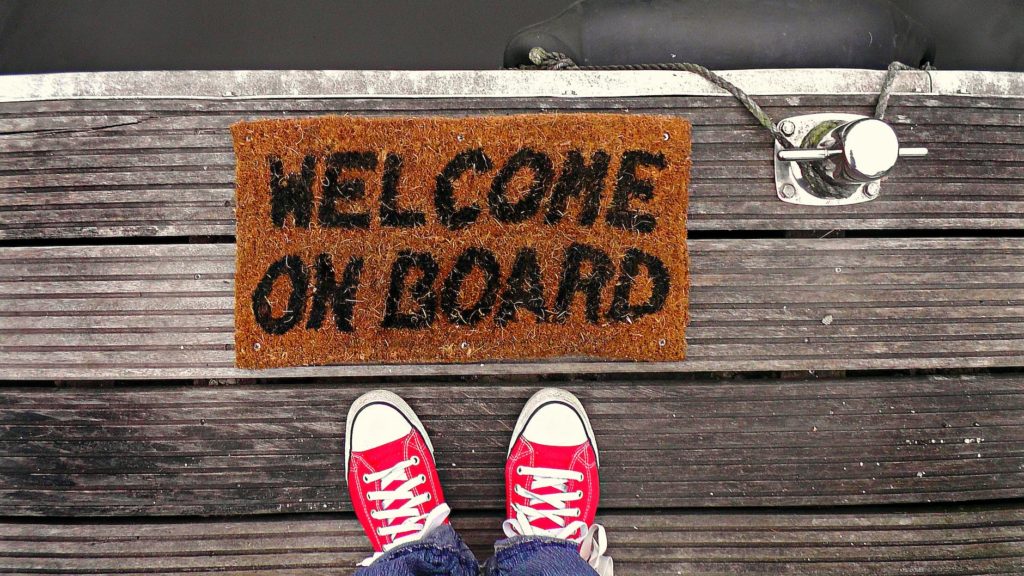 person standing near brown welcome on board printed floor map