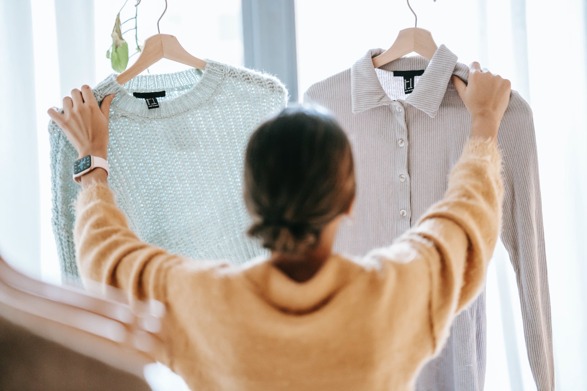 unrecognizable woman demonstrating clothes in store