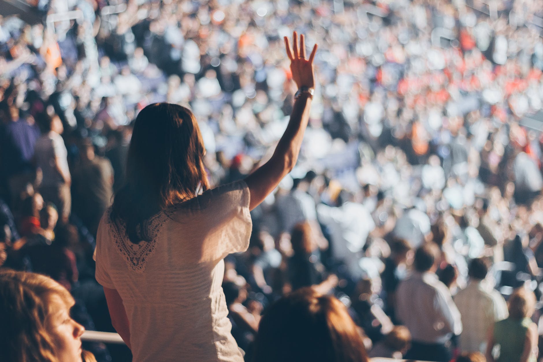 woman with white shirt raising her right hand
