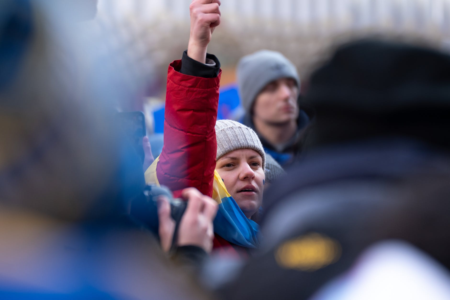 a woman in red jacket joining a protest